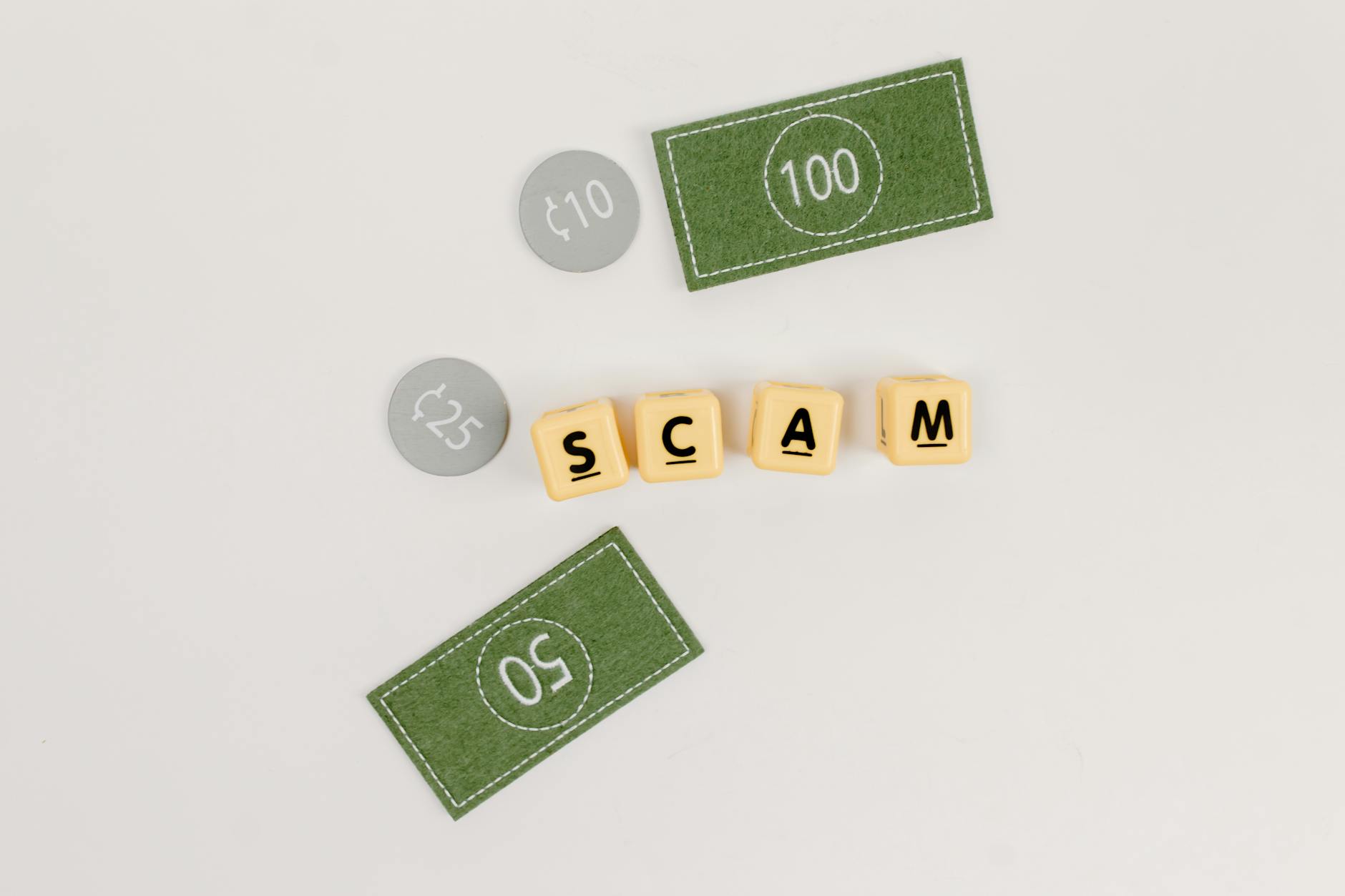 Flat lay of fake currency and scam letters on a gray surface representing financial deception.
